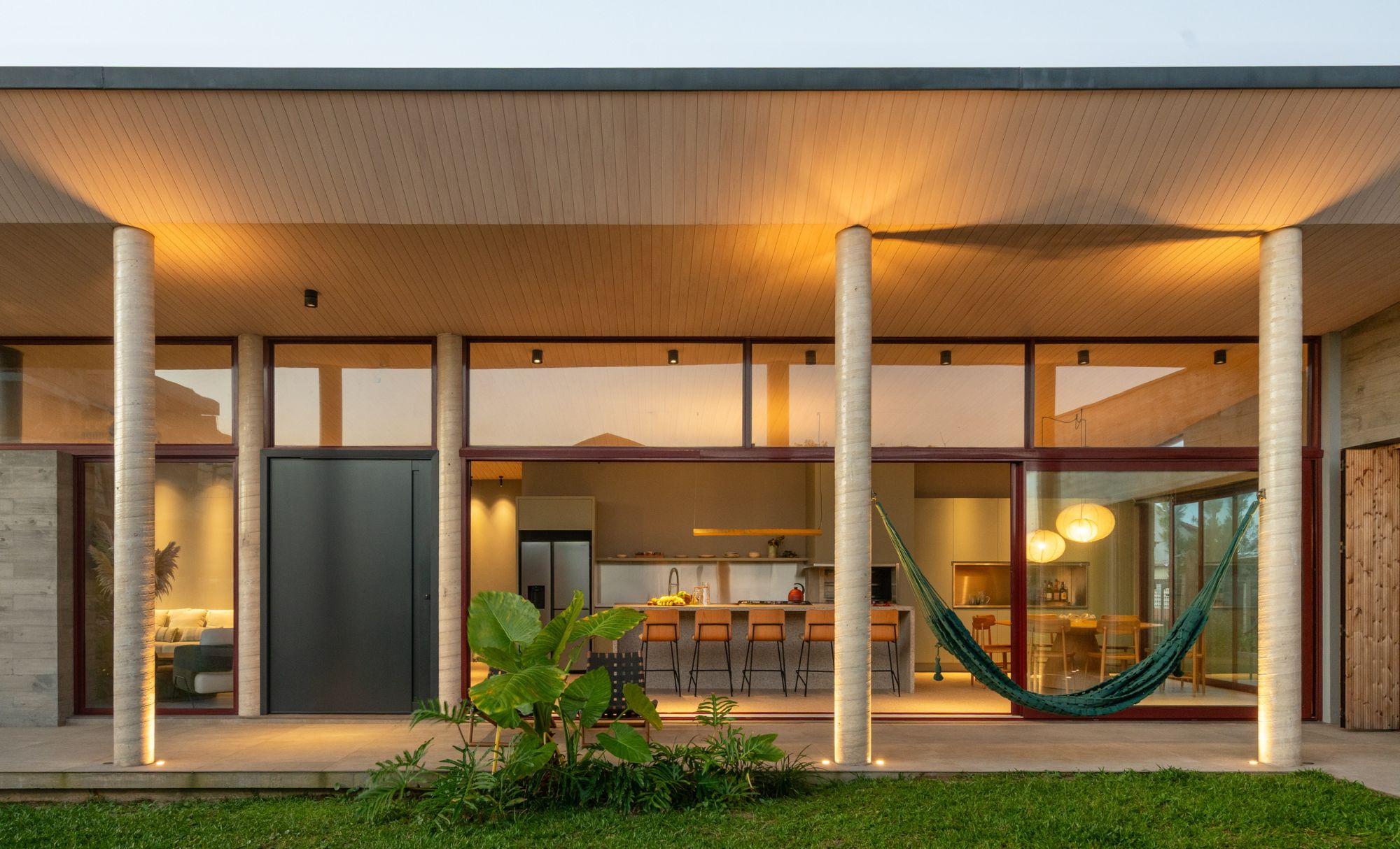 Casa entregue, com iluminação acesa ao entardecer